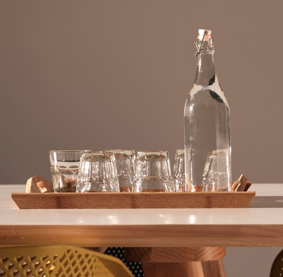 Photograph of a serving tray with a bottle of water and several glasses (turned upside down).