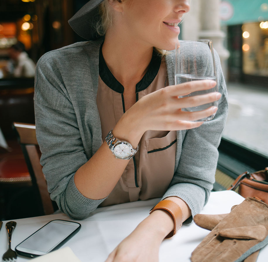 Photogarph of a woman holding a glass of water (restaurant setting)