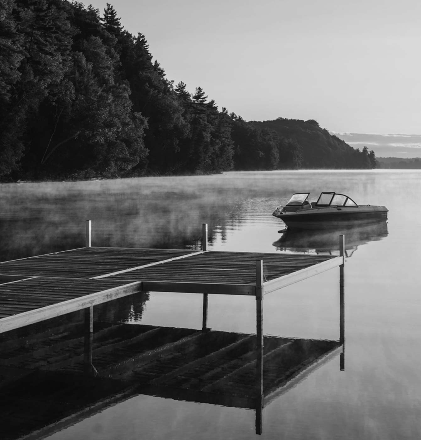 Photograph of a lake/cottage setting (with dock and boat pictured)
